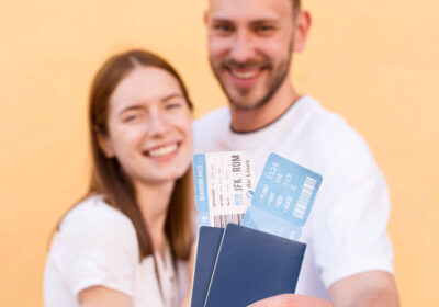 smiley-tourist-couple-showing-off-plane-tickets-passports